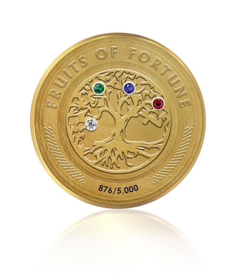 A gold coin adorned with a diamond, ruby, emerald, and sapphire
