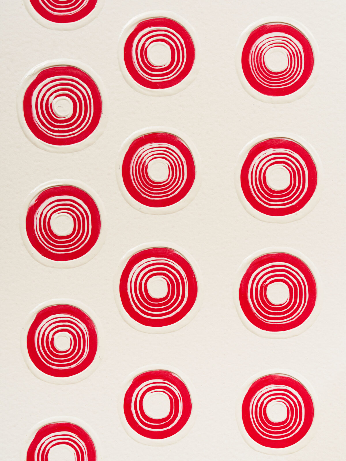 A grouping of red swirling circles on a grey-white background.