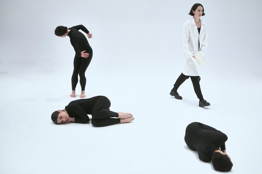 four individuals dancing in an empty room